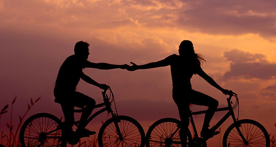 Man and women on bikes with sunset