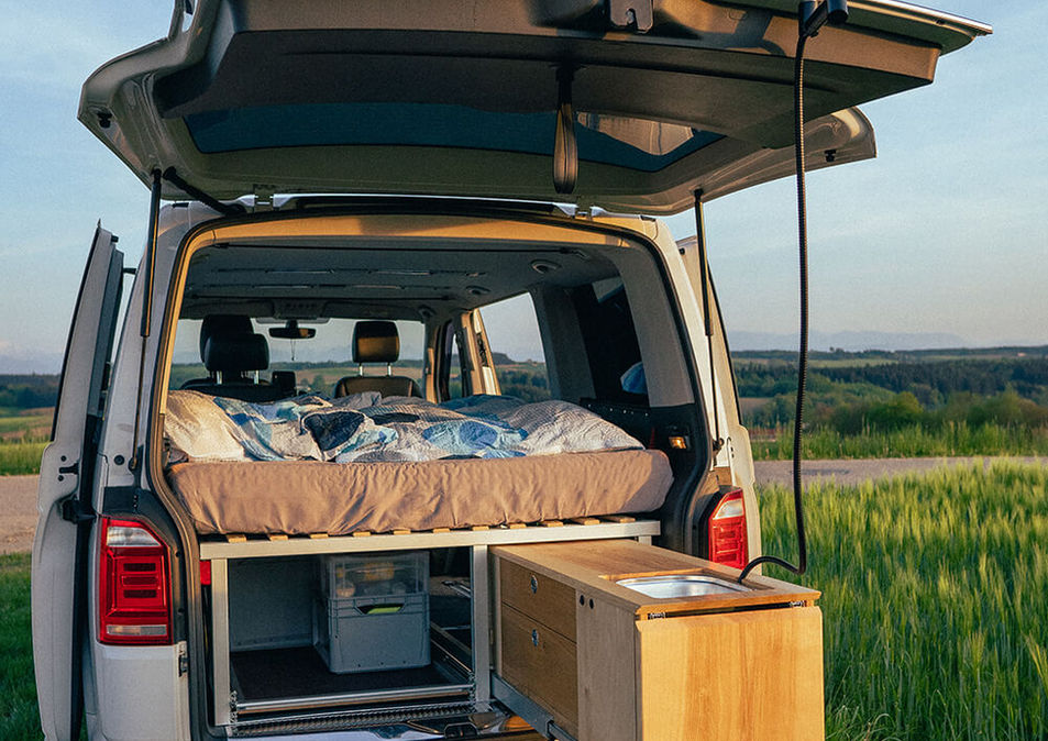 VW T6 Multivan Camper Ausbau mit ausziehbarem Bett und Küchenmodul im Freien
