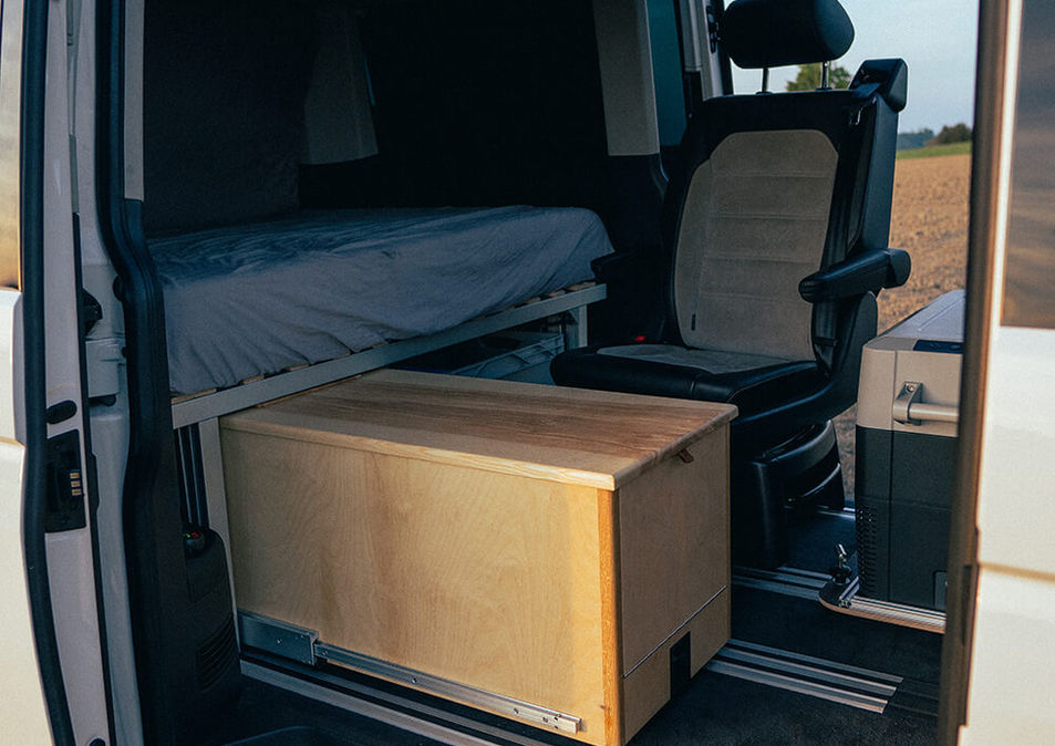 VW T6 Multivan Ausbau mit kompaktem Holzmodul auf Schienen und Schlafplattform