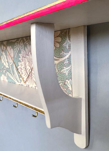 Cremefarbenes Wandregal im Jugendstil mit floraler Tapete und Haken