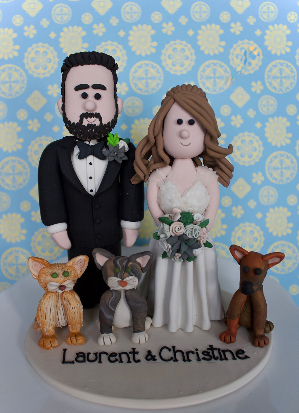 Clay bride and groom figurines with three pets. Dog & Cat Wedding Cake Topper for Bride and Groom