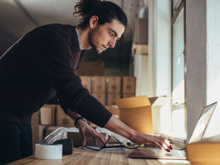 An owner packing customer orders, illustrating the cash conversion cycle from stock to customer receipts
