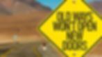 Yellow road sign with the text "Old Ways Won't Open New Doors" on a desert road background, suggesting change and new beginnings.