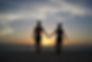 Couple holding hands at sunset