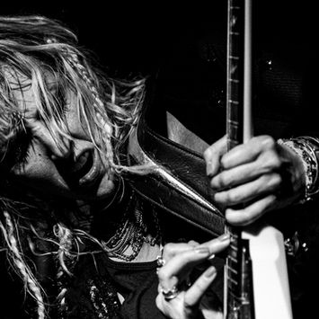 Brit Lightning of the band Vixen playing guitar two-hand tapping taken by Photographer Tom Prather of The Blue Wave Video Production Agency