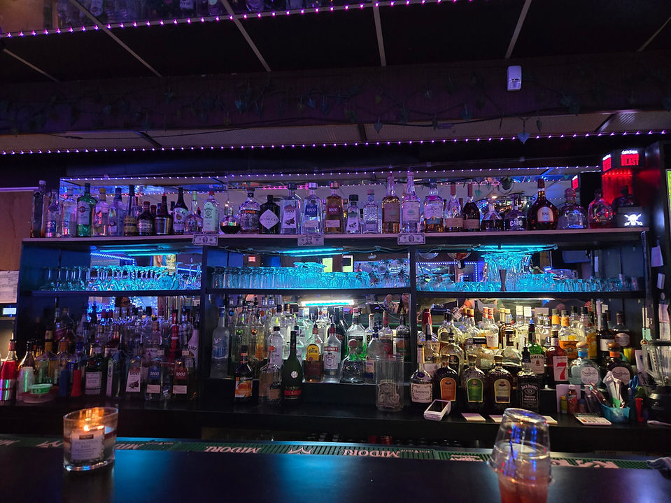 Shelves with alcohol behind the bar of New Star Inn Bar & Lounge