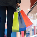 A person carrying shopping bags up the escalator