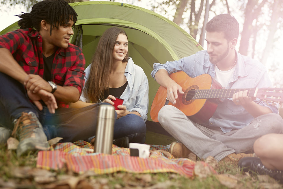 3 friends singing a song on a camping trip