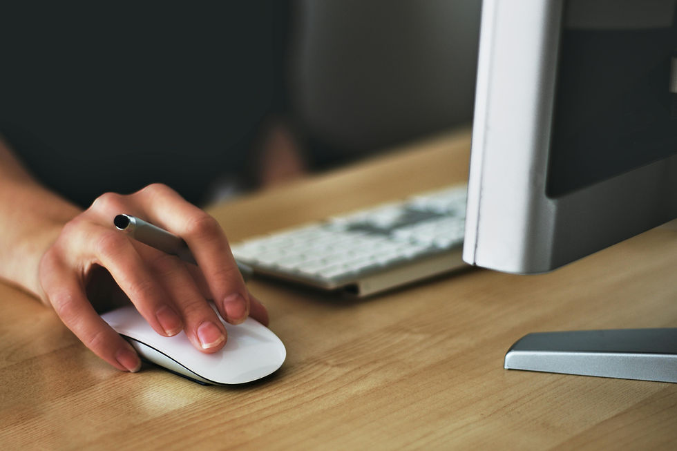 A woman with her hands on a mouse while using a computer