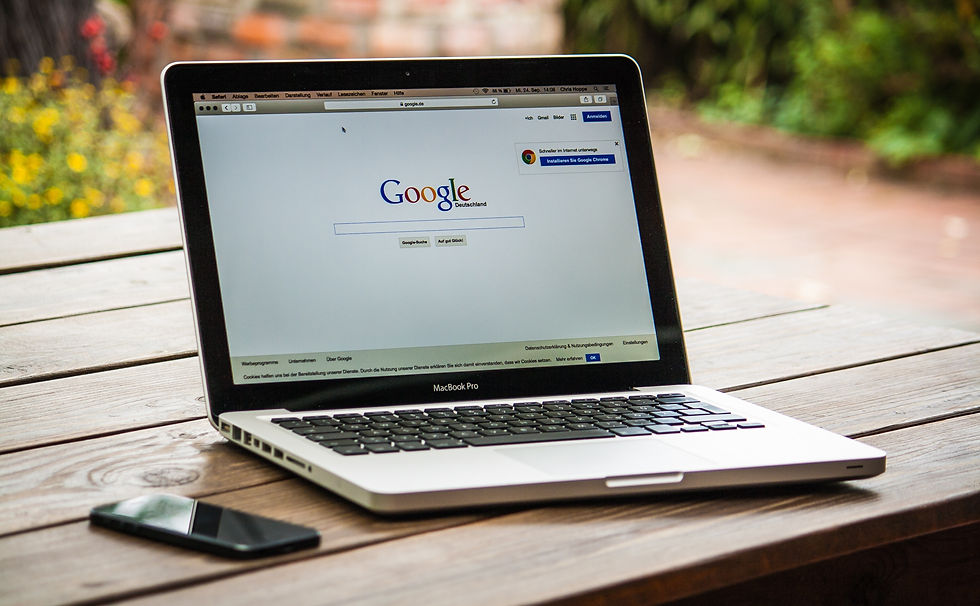 A laptop on the table with Google search page on the screen.