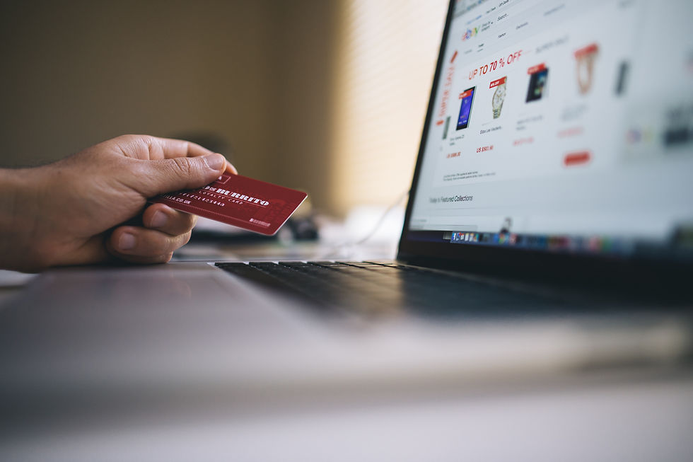 A man holding a credit card while scrolling on Amazon website