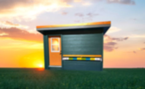 Bee Cube® building with a sunset/sunrise behind it. 