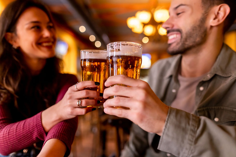 A male and female couple clinking beers