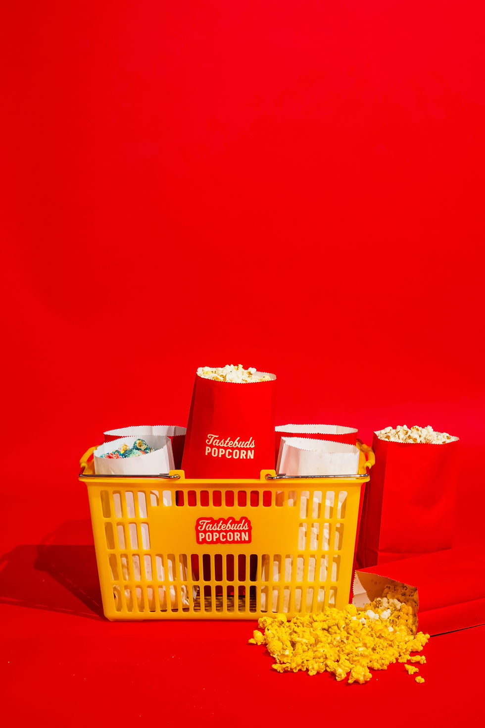 overflowing yellow grocery basket with red and white popcorn bags