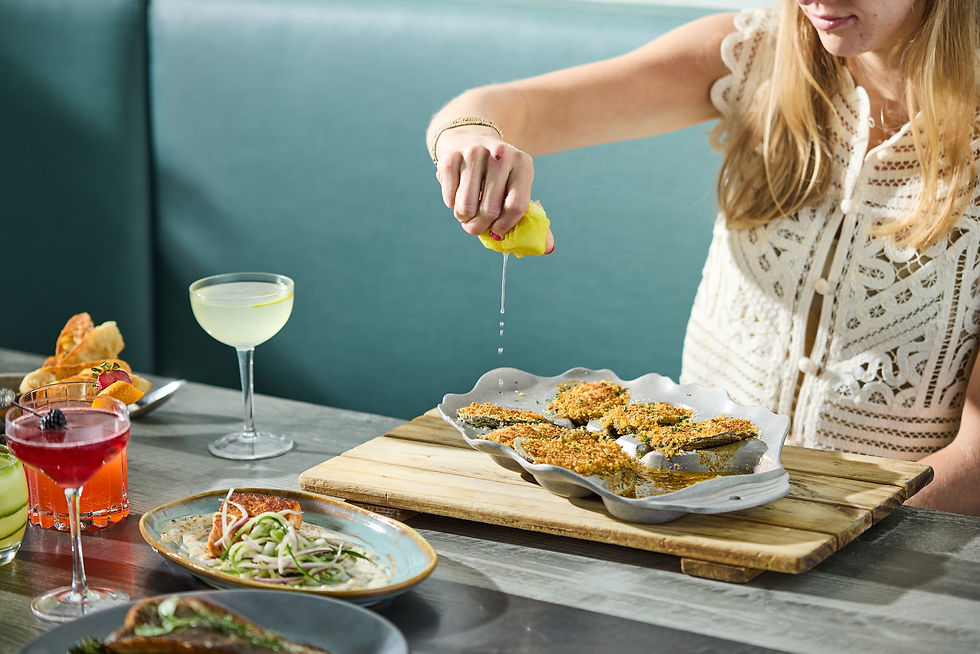girl squeezing lemon on oysters