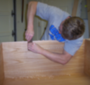 Photo of me working on a cabinet (scraping edge banding)