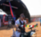Man on motorcycle with prayer flags at an event