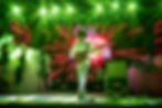 Bassist performing live on stage with green lighting