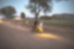 Motorcycle riding on a dusty road at dusk