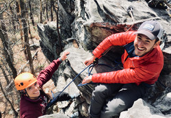 Man and woman rock climbing outdoors