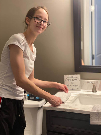 Woman folding a towel on a bathroom sink