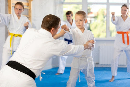 ad pic family-page-001_edited.jpg Martial Arts teacher helping student in class as family practices