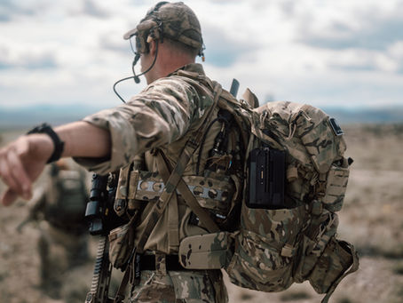     US Military Operator speaks on a headset while packing Darkhive's multi-rotor vehicle, Obelisk