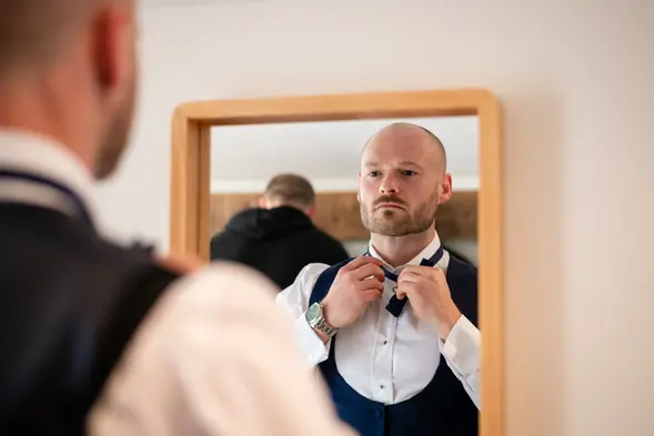 Groom adjusting tie or bow tie before the ceremony