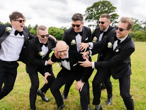 Groomsmen messing about in tuxedos