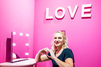Marie HARRY photographe assise devant un néon qui écrit LOVE