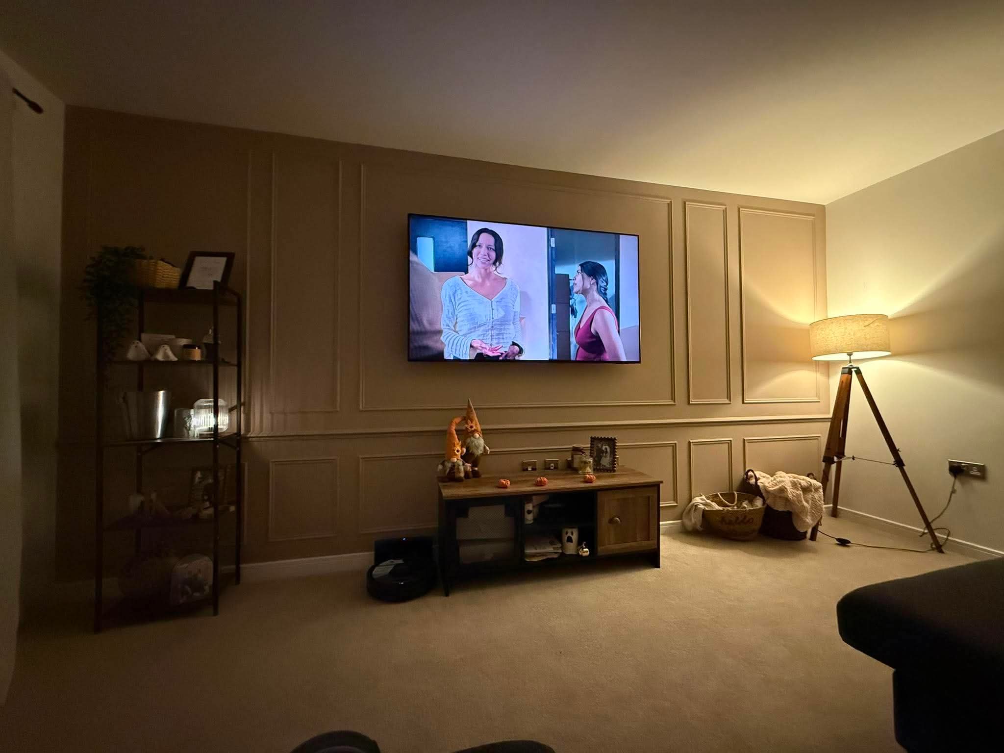 Completed living room wall panelling with a wall-mounted TV