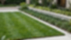 High end garden design with lush lawn and structured beds.