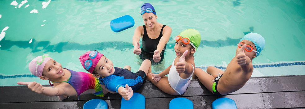 Cute swimming class and coach smiling at