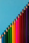 Colorful array of pencils on turquoise blue background