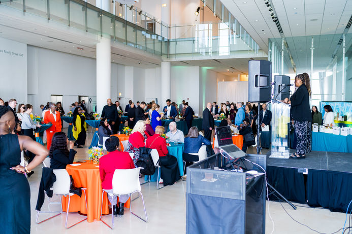 Supporters gather at a large indoor event with a speaker.