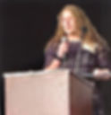 Young woman speaking into microphone at podium
