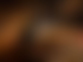 Hot water being poured over colorful tea leaves in a dark, textured bowl. Warm, earthy tones with scattered petals and spices. Cozy mood.