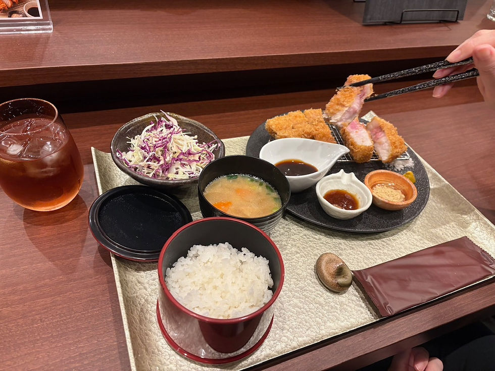 カウンター席で提供される「とんかつ えん」のとんかつ定食。手前にご飯と味噌汁、奥にとんかつとソース、小鉢、アイスティーが並ぶ。