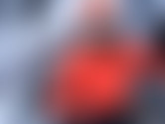 Climber wearing bright orange Arc'teryx jacket in snowy mountain conditions