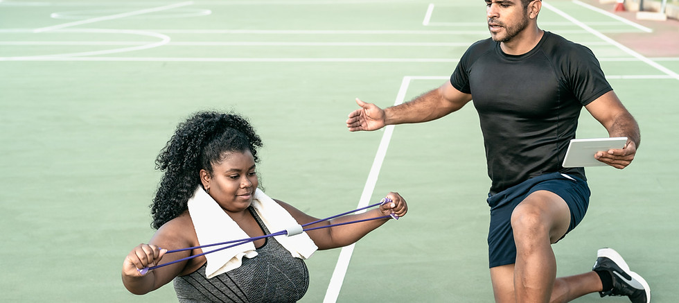 Woman using resistance band with trainer, exercise session on a mat