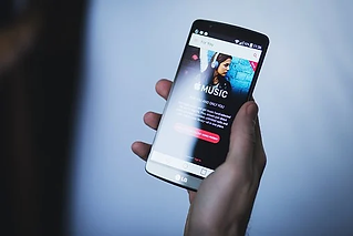 Hand holding a phone with apple music open