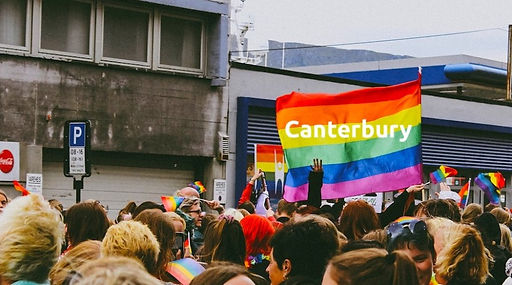 Pride parade with a pride flag reading "Canterbury"