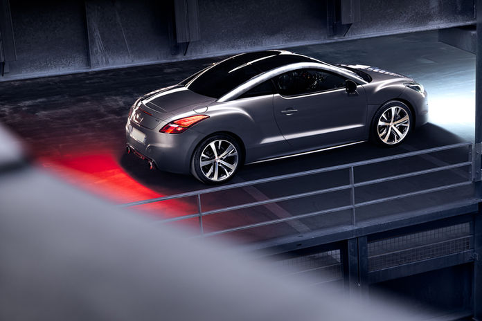 Arrière d'une Peugeot RCZ grise dans un parking en light painting