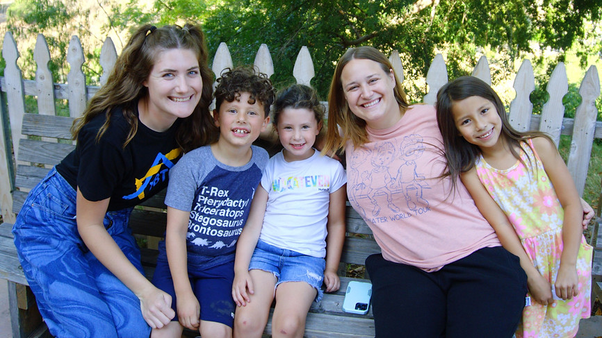 Three children pose with their two after school teachers