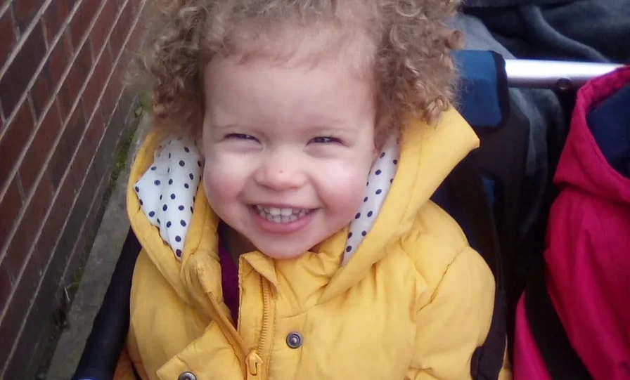 Child in yellow coat smiling