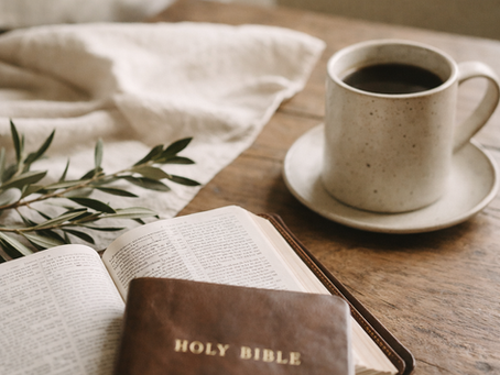 Open Bible and coffee on a wooden table, representing quiet reflection, faith, and intentional living.