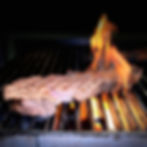 Steak grilling over an open flame on a barbecue grill