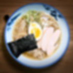 Bowl of ramen with soft-boiled egg, chicken, and nori