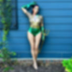 Nina Unrated in aquaman cosplay holding a golden trident against blue siding