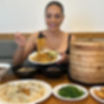 Nina Unrated holding a fork with noodles over various Asian dishes.